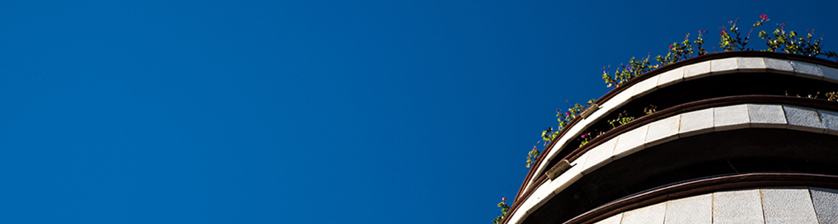 Όψη των τελευταίων τριών ορόφων πολυκατοικίας με καθαρό γαλάζιο ουρανό