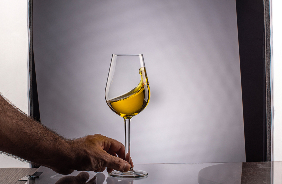 Χέρι κρατάει ποτήρι κρασί στο στούντιο φωτογραφίας